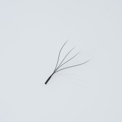 Κοντινή λήψη (macro) ενός έτοιμου fan βλεφαρίδων (premade fan) 4D, αποτελούμενου από 4 λεπτές, μαύρες ίνες ενωμένες στη βάση με μακρύ κορμό (long stem), για τεχνική volume.